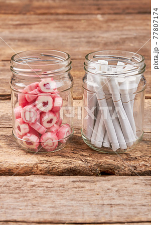 Glass jar with tobacco cigarettes. Glass jar with tobacco cigarettes. 77807174