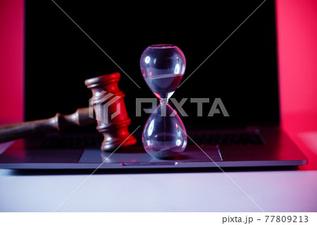 Judge's gavel, scales of justice and hourglass on laptop. Law and justice concept 77809213