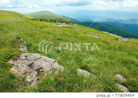 stones on the hill of mountain meadow. beautiful summer landscape with clouds above the horizon 77809404