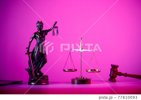 Statue of Lady Justice with scales on the table in purple neon. Symbol of justice and law 77810093