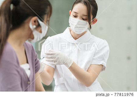 ワクチンを接種する医療従事者 77811976