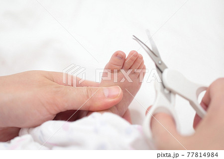 新生児の足の爪切りをするママ 77814984