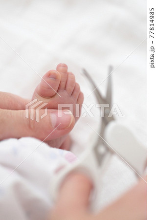 新生児の足の爪切りをするママ 77814985