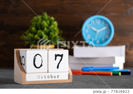 October 07th. October 07 wooden cube calendar with blur objects on background. October 07th. October 07 wooden cube calendar with blur objects on background. 77816622