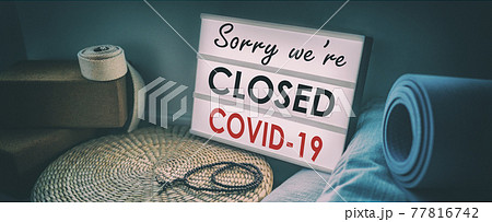 Fitness gym Sorry we are closed sign at yoga studio because of coronavirus. Businesses shutdown due to pandemic. Lit Sign at pilates indoor class with equipment. Banner background 77816742