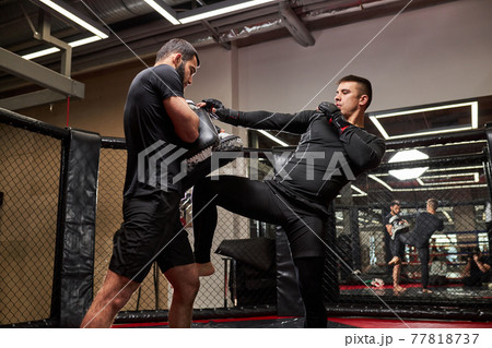 Mixed martial artists training before fight, practice kickboxing, strength and motivation Mixed martial artists training before fight, practice kickboxing, strength and motivation 77818737