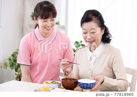 介護イメージ　食事をするシニア女性と介護士 77818960