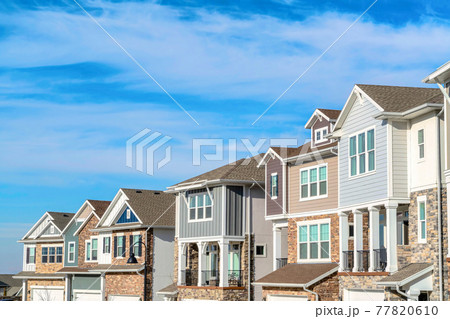 Multi storey homes with balconies and sliding windows against cloudy blue sky Multi storey homes with balconies and sliding windows against cloudy blue sky 77820610