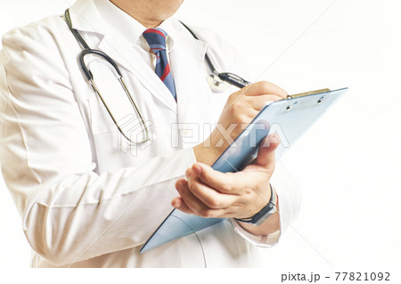 Close-up of a doctor filling out a medical form on a clipboard while standing in a hospital 77821092