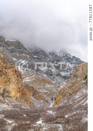 Amazing mountain scenery with steep and rocky slope dusted with snow in winter Amazing mountain scenery with steep and rocky slope dusted with snow in winter 77821387