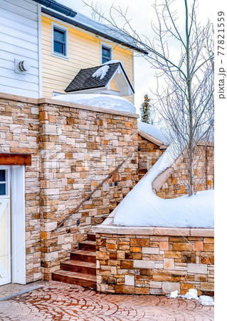 Facade of house with snowy stairs that leads to the entrance against cloudy sky 77821559