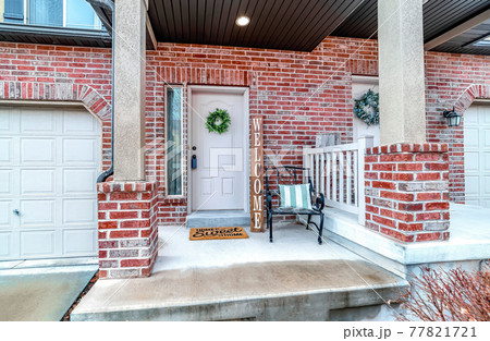 Front of apartment building with white front door and red brick exterior wall Front of apartment building with white front door and red brick exterior wall 77821721