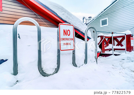 No Construction Parking sign on a curvy metal pipe fence against snow in winter 77822579