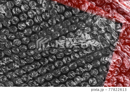 Abstract black red plastic background with bubble wrap and adhesive tape. Diagonal view 77822613