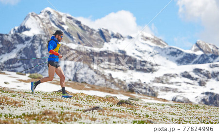 Trail athlete in downhill mountains with sticks Trail athlete in downhill mountains with sticks 77824996