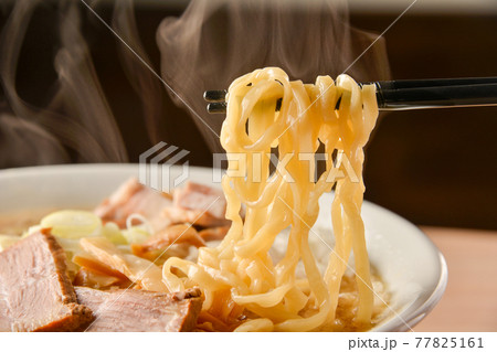 ラーメンの麺を箸であげている写真 77825161
