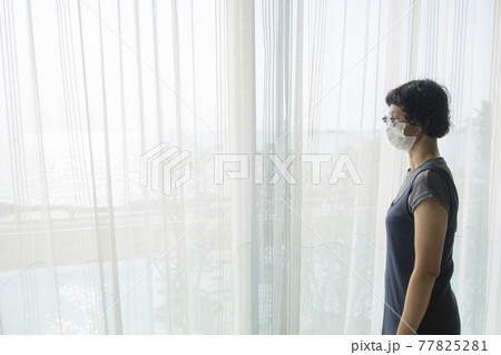 Asian female tourists wear gray clothes, glasses and face masks in State Quarantia. 77825281
