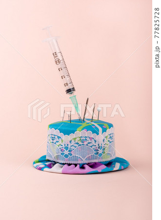 A medical syringe in a needle pad among sewing needles. A medical syringe in a needle pad among sewing needles. 77825728