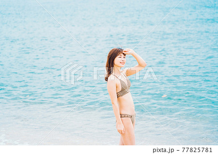 海辺を歩く水着の女性 77825781