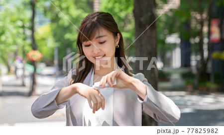 外で日焼け止めを塗る若い女性 77825982