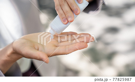 外で日焼け止めを塗る若い女性 77825987