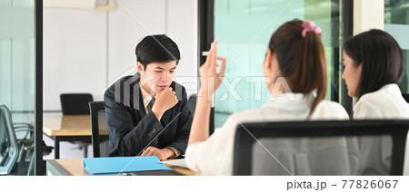 Women are talking with the Loan department staff while sitting together at the working table. Women are talking with the Loan department staff while sitting together at the working table. 77826067