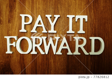 Pay It Forward alphabet letter on wooden background 77826812