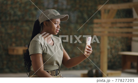 Delighted black military woman speaking with online friend Delighted black military woman speaking with online friend 77827205