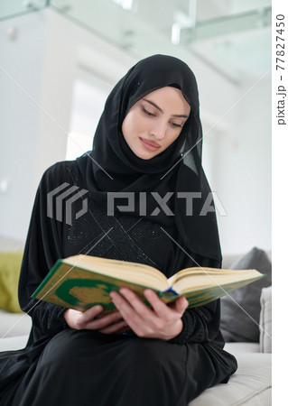 Portrait of young muslim woman reading Quran in modern home Portrait of young muslim woman reading Quran in modern home 77827450
