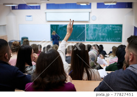 female student sitting in the class and raising hand up female student sitting in the class and raising hand up 77827451