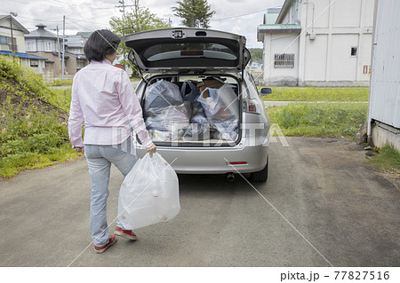 家庭ゴミを車に乗せる女性 家庭ゴミを車に乗せる女性 77827516