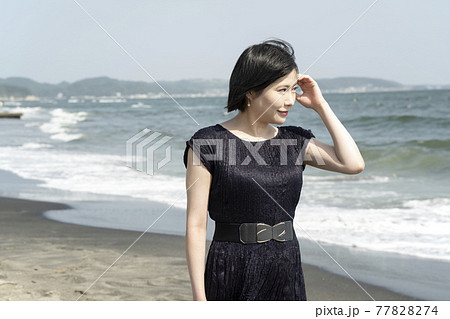 海風に吹かれながら砂浜の波打ち際を歩く若い女性(神奈川県鎌倉市七里ヶ浜) 海風に吹かれながら砂浜の波打ち際を歩く若い女性(神奈川県鎌倉市七里ヶ浜) 77828274