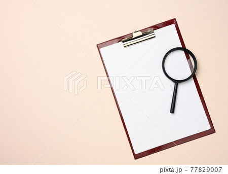 folder with blank white sheets and a black magnifier on a beige background. Background for inscriptions folder with blank white sheets and a black magnifier on a beige background. Background for inscriptions 77829007