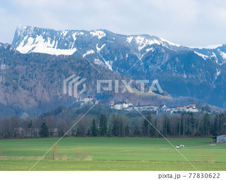 Historic town and Chateau de Gruyeres, Switzerland, in front of the mountains 77830622