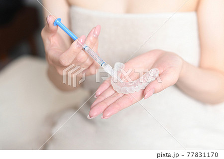 ホームホワイトニングのマウスピースにジェルを塗るイメージ 77831170