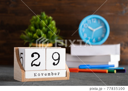 November 29th. November 29 wooden cube calendar with blur objects on background. 77835100