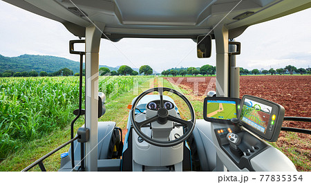 Autonomous tractor working in corn field, Future technology with smart agriculture farming concept Autonomous tractor working in corn field, Future technology with smart agriculture farming concept 77835354