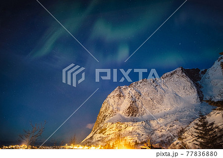 Aurora borealis over snow mountain in Reine town at Lofoten Islands Aurora borealis over snow mountain in Reine town at Lofoten Islands 77836880