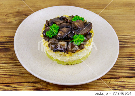 Tasty layered salad with roasted mushrooms, potato, eggs, cheese and mayonnaise on wooden table Tasty layered salad with roasted mushrooms, potato, eggs, cheese and mayonnaise on wooden table 77846914