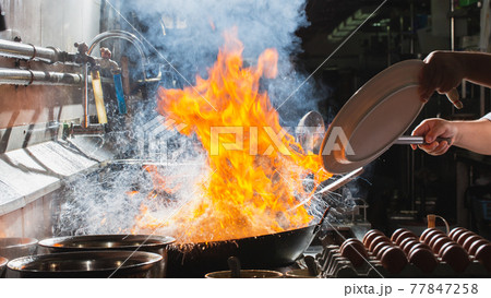 Chef stir fry busy cooking in kitchen Chef stir fry busy cooking in kitchen 77847258