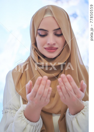 Portrait of young muslim woman praying or making dua to God Portrait of young muslim woman praying or making dua to God 77850559