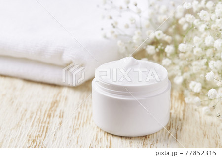 jar of face skin care cream for moisturizing and relaxing facial skin, on a white table, copy space for text. 77852315