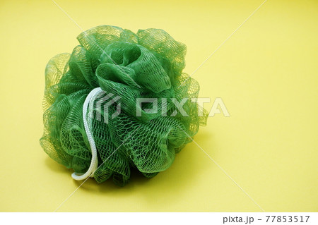 Green bath soft with rope on Yellow background Green bath soft with rope on Yellow background 77853517