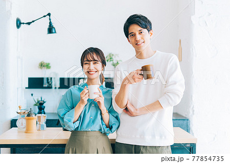 コーヒーカップを持つ若い夫婦 カップル 77854735