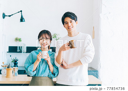 コーヒーカップを持つ若い夫婦 カップル 77854736