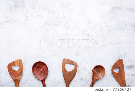 Various heart shape of wooden cooking utensils. Wooden spoons and wooden spatula on white concrete background with flat lay and copy space. Various heart shape of wooden cooking utensils. Wooden spoons and wooden spatula on white concrete background with flat lay and copy space. 77856427