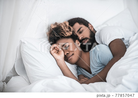 Man hugging his wife sleeping in bedroom Man hugging his wife sleeping in bedroom 77857047
