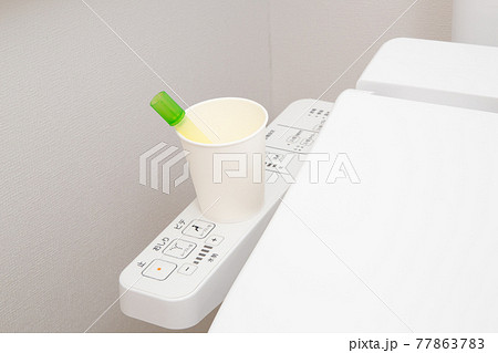 尿検査　検尿　(便器の上に置かれた検査キット) 77863783