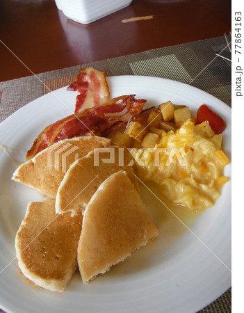 パンケーキとポテトとベーコンとスクランブルエッグの朝食プレートの写真素材