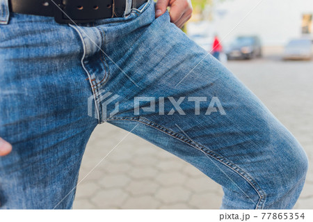 Low Section View Of Person's Wet Jeans Standing On Carpet. 77865354